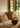 Ruang tamu bergaya pedesaan yang didekorasi dengan bantal yang ditenun tangan bernuansa sederhana dan lembut di atas sofa tiga dudukan berwarna putih.